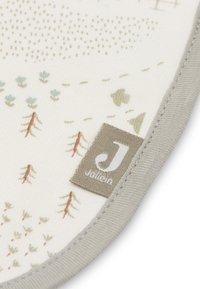 Zachte stoffen hoek met een genaaide grijze label met de tekst "Jollein" en kleine bedrukte boompjes en bloemenpatronen op een witte achtergrond.