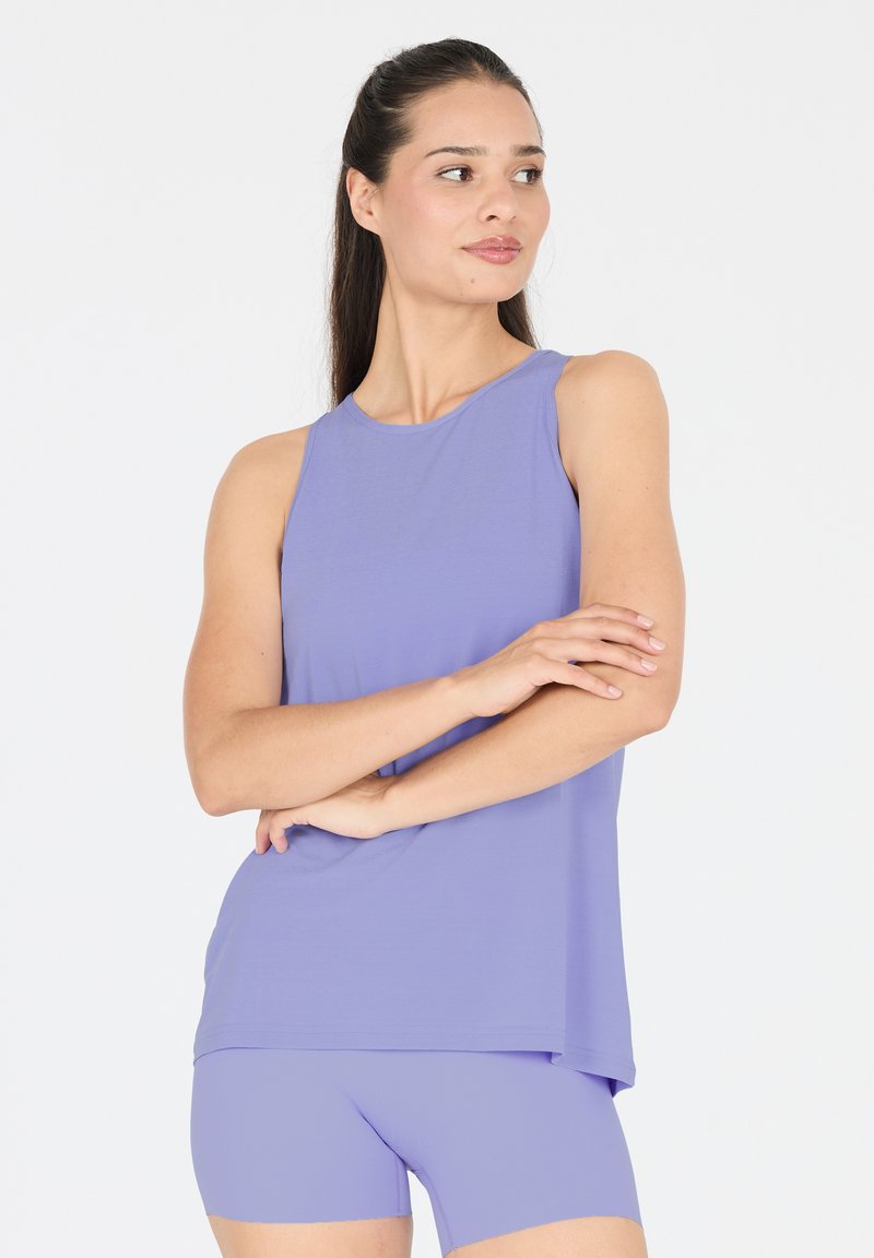 Top atletico senza maniche di colore viola con scollatura rotonda e vestibilità ampia, abbinato a pantaloni corti viola coordinati, realizzati in un tessuto liscio e elasticizzato.