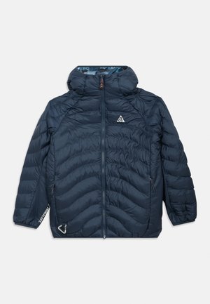 Marineblauwe geïsoleerde jas met een capuchon, gequiltde textuur, ritssluiting aan de voorkant en logo-details. Inclusief zijzakken en elastische manchetten.