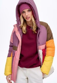 Wielokolorowa puchowa kurtka z kapturem; posiada odcienie różu, pomarańczy, żółtego i brązowego; gładka tekstura; zapięcie na zatrzaski i suwak.