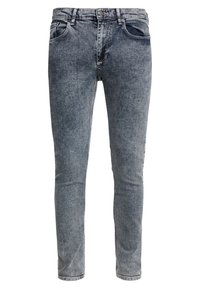 Vaqueros de mezclilla azul claro con un ajuste slim, diseño de cinco bolsillos y detalles de costura en contraste. La tela tiene una ligera textura desgastada.