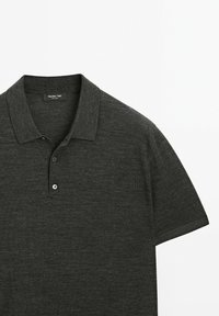 Polo shirt grigio scuro realizzato in tessuto testurizzato, con colletto classico, pattina con tre bottoni e maniche corte. Etichetta del marchio visibile.