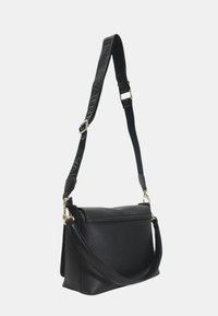 Borsa a tracolla in pelle nera martellata con tracolla staccabile. Caratterizzata da hardware dorato, una forma strutturata e una superficie testurizzata.