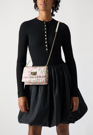 Väike roosa õlavöökott lilledega mustriga, kuldsete detailidega ja ahelaga rihmaga. Kandmiseks musta soonikkoes T-särgi ja volüümika musta seeliku peal.