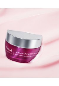 Murad Nutrient-Charged Water Gel i en rund lila burk med ett silverlock, mot en mjuk rosa bakgrund. Burken har vit text.
