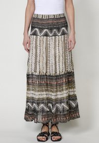 Maxi rok met een patronenontwerp in zwart, wit en aardetinten. De elastische tailleband en de gelaagde ruffle zoomdetails verbeteren de vloeiende silhoelet.