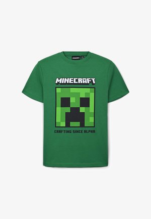 Zielona bawełniana koszulka z czarnym i zielonym wzorem Creepera z Minecrafta oraz napisem "MINECRAFT" i "CRAFTING SINCE ALPHA" poniżej.