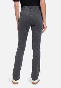 Jean flair gris en denim avec une taille haute, des poches arrière et une texture lisse. Complète un style de chaussures décontracté.