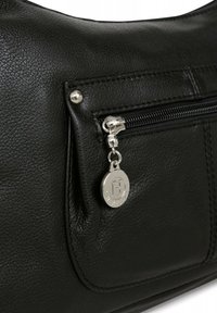 Borsa a mano in pelle nera con una tasca anteriore a zip, accessori in argento e un charm con logo in metallo. Superficie testurizzata con cuciture visibili.