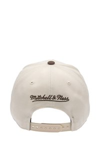Beige cap with a rounded shape and a brown embroidered logo "Mitchell & Ness" on the back. Features a plastic snap closure.