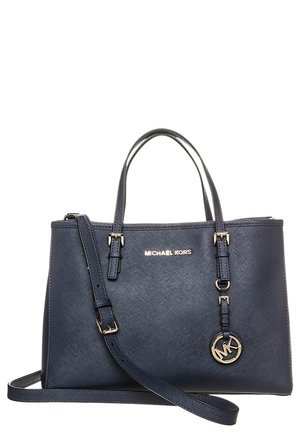 Marineblauwe Michael Kors handtas met twee handvatten, een verstelbare schouderriem en een ronde gouden logo-bedel aan de voorkant.
