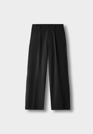 Black high-waist wide-leg pants with front pleats, side pockets, belt loops, and a button closure on a light gray background.