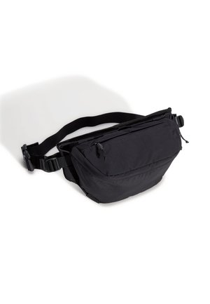 Schwarze Bauchtasche aus Stoff mit geschwungener Form, verstellbarem Riemen, Reißverschlusstasche und glatter Textur. Verfügt über ein praktisches, minimalistisches Design.