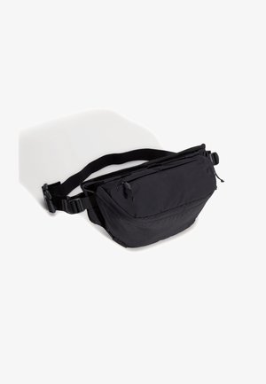 Black fabric hip bag with a curved shape, adjustable strap, zippered pocket, and smooth texture. Features a practical, minimalist design.
