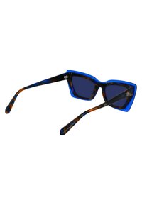 Ochelari de soare tip cat-eye cu rame albastre, brațe cu imprimeu țestoasă, lentile întunecate și un design geometric îndrăzneț. Prezintă un logo pe tempă.