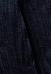 Ciemnoniebieska tkanina z żeberkową teksturą, z pionowymi liniami; miękki, puszysty materiał z delikatnym blaskiem.