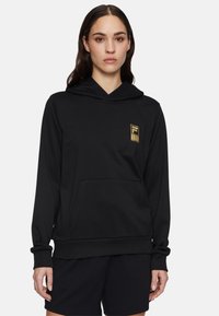 Svart hoodie med framficka, ribbade ärmslut och nederkant. Har en liten gul logotyp på bröstet. Mjukt, stretchigt tyg.