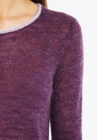 Sweter dziany w głębokim fioletowym odcieniu, z teksturowaną tkaniną i kontrastującym jasnoszarym dekoltem. Zbliżenie na tułów i rękawy.