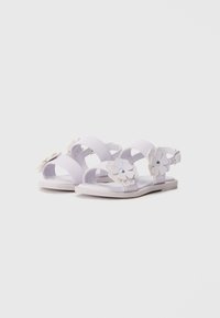 Lilla sandaler med blomsterdetaljer, laget av syntetisk materiale, med åpen tå-design og ankelstropp for trygg passform.