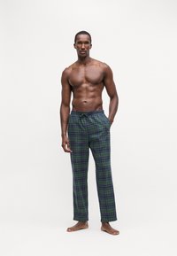 Kockované pyžamové nohavice v zelenej, námorníckej a fialovej farbe, s pásom na šnúrku a voľným strihom. Mäkká tkanina, celodĺžkový dizajn.