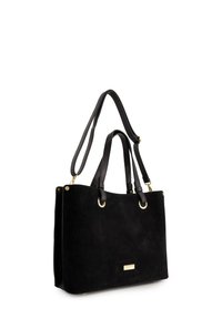 Sort ruskinds-tote med sorte læderhåndtag, gyldne hardware-detaljer og rektangulær form. Har dobbelte top-håndtag og en struktureret design.