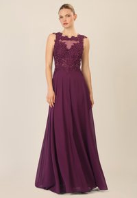 Langes lila Kleid mit einem taillierten Oberteil, das florale Perlenverarbeitung und einen transparenten Halsauschnitt aufweist; fließender Rock aus weichem, strukturiertem Stoff.