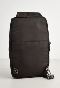 Borsa nera in nylon di forma rettangolare, con zip frontale, hardware laterale e texture liscia. Design semplice e funzionale.
