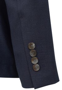 Manica di giacca blu navy con tessuto texturizzato e quattro bottoni rotondi marroni con un design floreale, disposti verticalmente lungo il polsino.