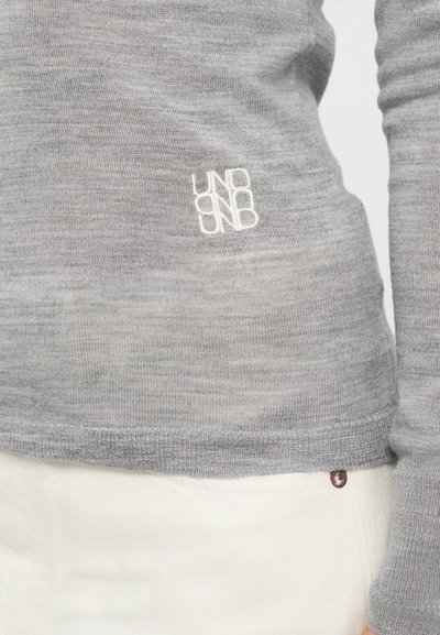Light grey long-sleeve sweater made of soft material, featuring a small white embroidered logo on the hem and ribbed cuffs.