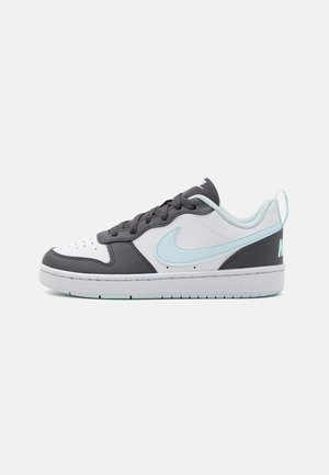 Niskie sneakersy w kolorach białym, czarnym i jasnoniebieskim, z czarnymi sznurówkami oraz jasnoniebieskim logo Nike Swoosh po boku.