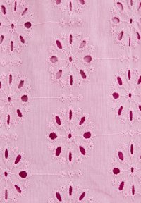 Gaiši rozā audums ar sarežģītu ziedu izšuvumu un izgrieztām dizainiem tumšāk rozā krāsā. Tekstūra ar paceltām šuvēm un detalizētām rakstām.