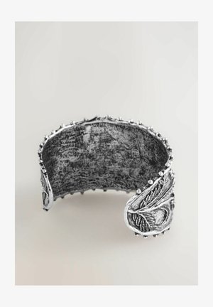 Silver cuff bracelet featuring a textured surface, leaf motif accents, and rounded edges with small decorative beads along the rim.