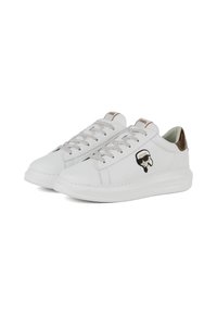 Sneaker bianche in pelle con lacci grigi, un accento marrone sul tallone e un logo grafico nero sul lato esterno. Suola in gomma.