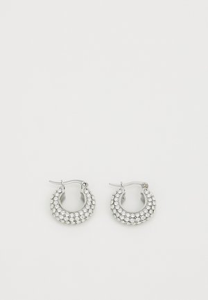 Srebrne kolczyki w kształcie obręczy zdobione małymi, przezroczystymi kamieniami, z zakrzywionym designem i bezpiecznym zapięciem do noszenia.