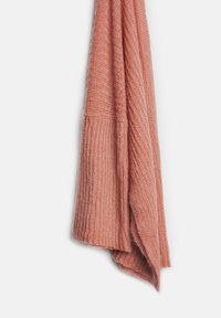 Dziana szal w miękkim koralowym kolorze z prążkowaną fakturą. Posiada złożony brzeg dla dodatkowego ciepła i elegancko się układa.
