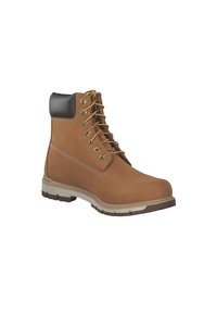 Botas de tobillo de cuero marrón con cordones amarillos, ojales de metal y un cuello de tela negra. Cuentan con una suela de goma con un diseño texturizado para mayor agarre.