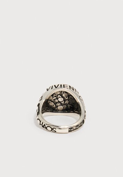 Sølvring med indgraveret "VIVIENNE" på toppen, "CHAOS" på siden og en tekstureret inderside med cirkulære og stjerneformede mønstre.