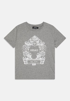 T-shirt grigio a maniche corte con una grafica bianca ornata che presenta leoni e la scritta "VERSACE EST. 1978" al centro. Materiale in cotone.