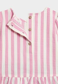 Vestido a rayas en rosa y blanco con una tapeta abotonada y un dobladillo con volantes. Fabricado en un tejido ligero con una textura suave.