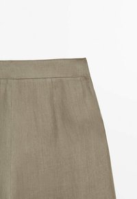 Jupe kaki taille haute avec une ceinture unie et des coutures discrètes, confectionnée dans un tissu texturé et léger.