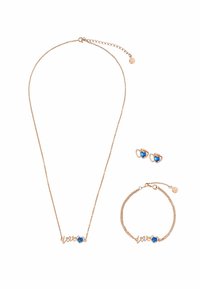 Conjunto de joyería en oro rosa que incluye un collar, una pulsera y pendientes, cada uno con un diseño de corazón y acentos de piedras preciosas azules.