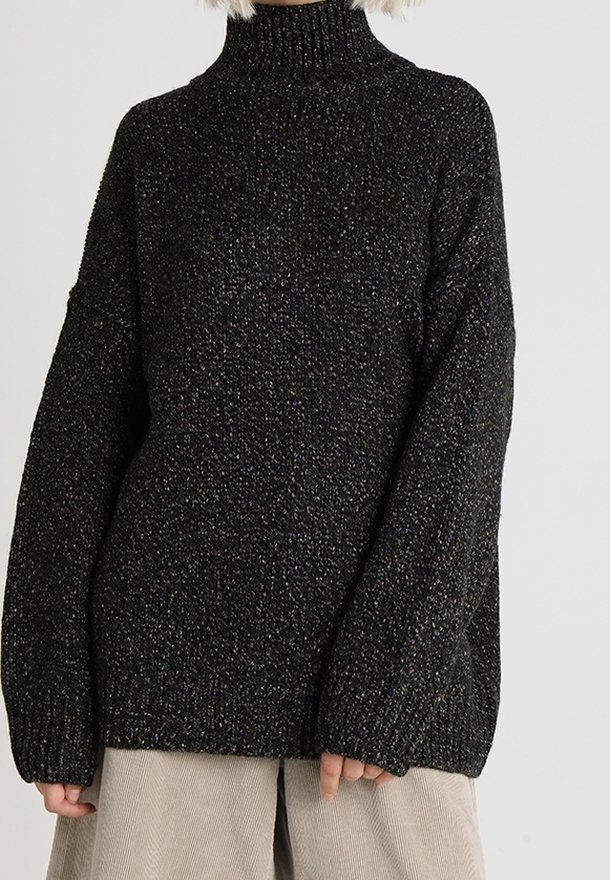 Black knitted turtleneck sweater with a loose fit, textured fabric, and long sleeves. Subtle metallic thread accents add visual interest.