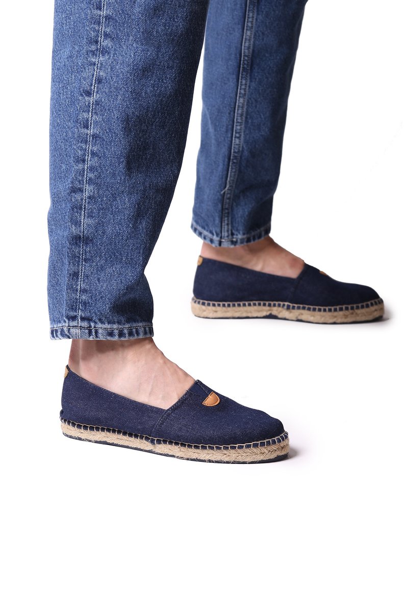 Marine canvas espadrilles met een jute zool, voorzien van een uitsnede aan de zijkant en leren accent bij de teen. Gecombineerd met opgerolde denimbroeken.