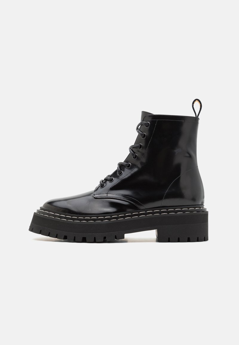 Schwarze, glänzende Stiefeletten mit Schnürdesign, ausgestattet mit einer dicken, strukturierten Sohle und Kontrastnähten entlang der Kante. Robust und langlebig.