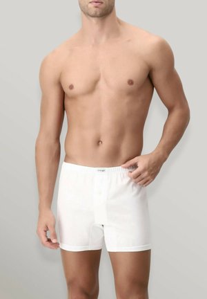 Boxer da uomo bianchi con elastico in vita, dotati di apertura con bottoni e realizzati in un tessuto leggero e morbido. Progettati per comfort e vestibilità.