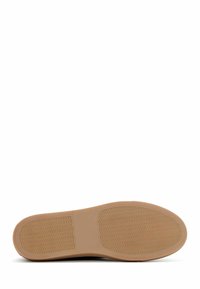 Suola della scarpa in gomma beige con un motivo di trazione ondulato e un profilo liscio, progettata per durata e aderenza su diverse superfici.