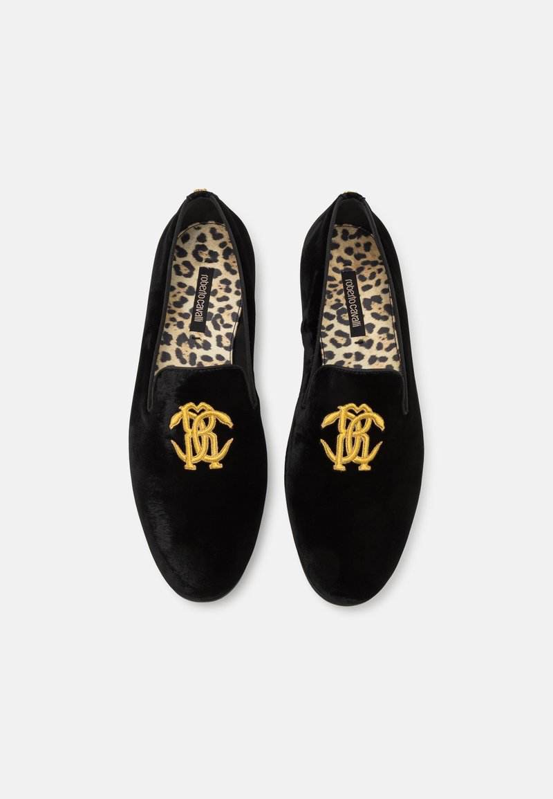 Los zapatos deslizables de terciopelo negro presentan un logotipo bordado en oro, un forro de estampado de leopardo y una textura suave. Diseño clásico con hardware mínimo.