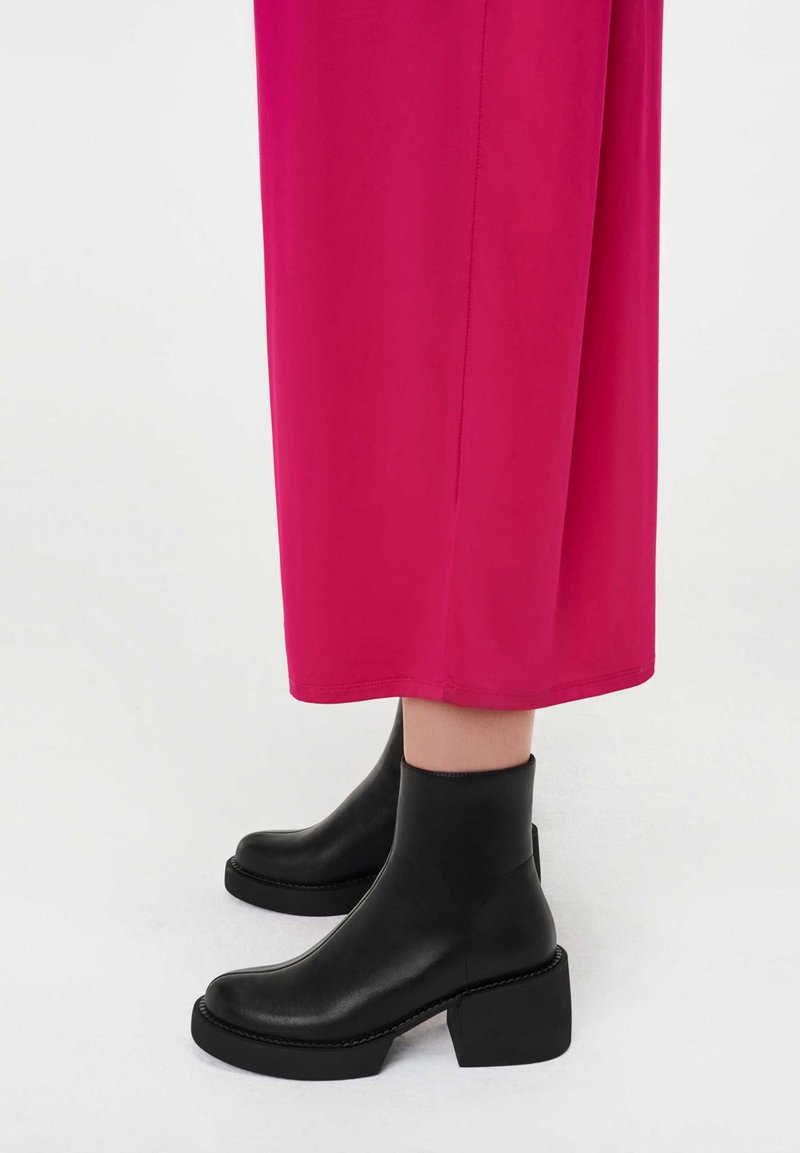 Mustad õlakad taldadega, plokksiis mingi ja paksu tallaga, kombineeritud erkroosa, pahkluud ulatuva riietusega.