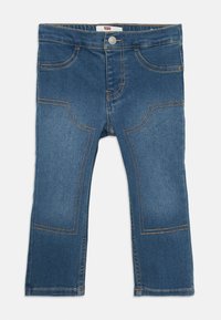Jeans per bambini in denim blu con dettagli di cucitura curva e chiusura a bottone, distesi su uno sfondo bianco.