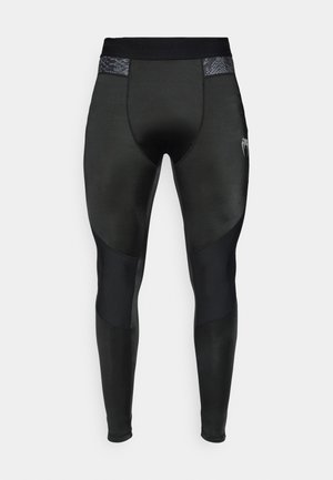 Leggings atletici neri con una texture liscia, pannelli a contrasto opachi e lucidi e una fascia in vita con motivo. Logo sul lato inferiore.